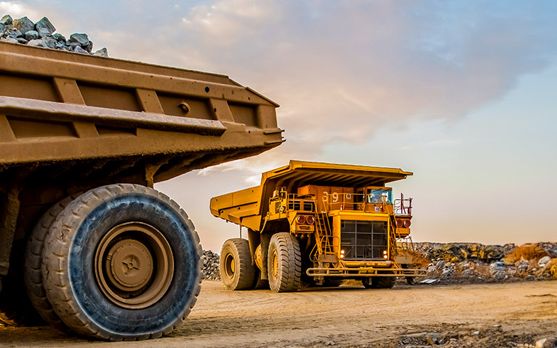 Machinery and dumping trucks outside a coal mining site